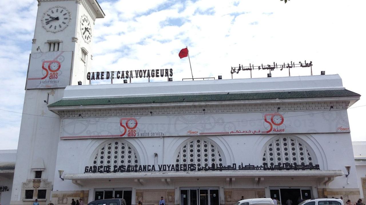 Travelers comparing bus and train options in Morocco